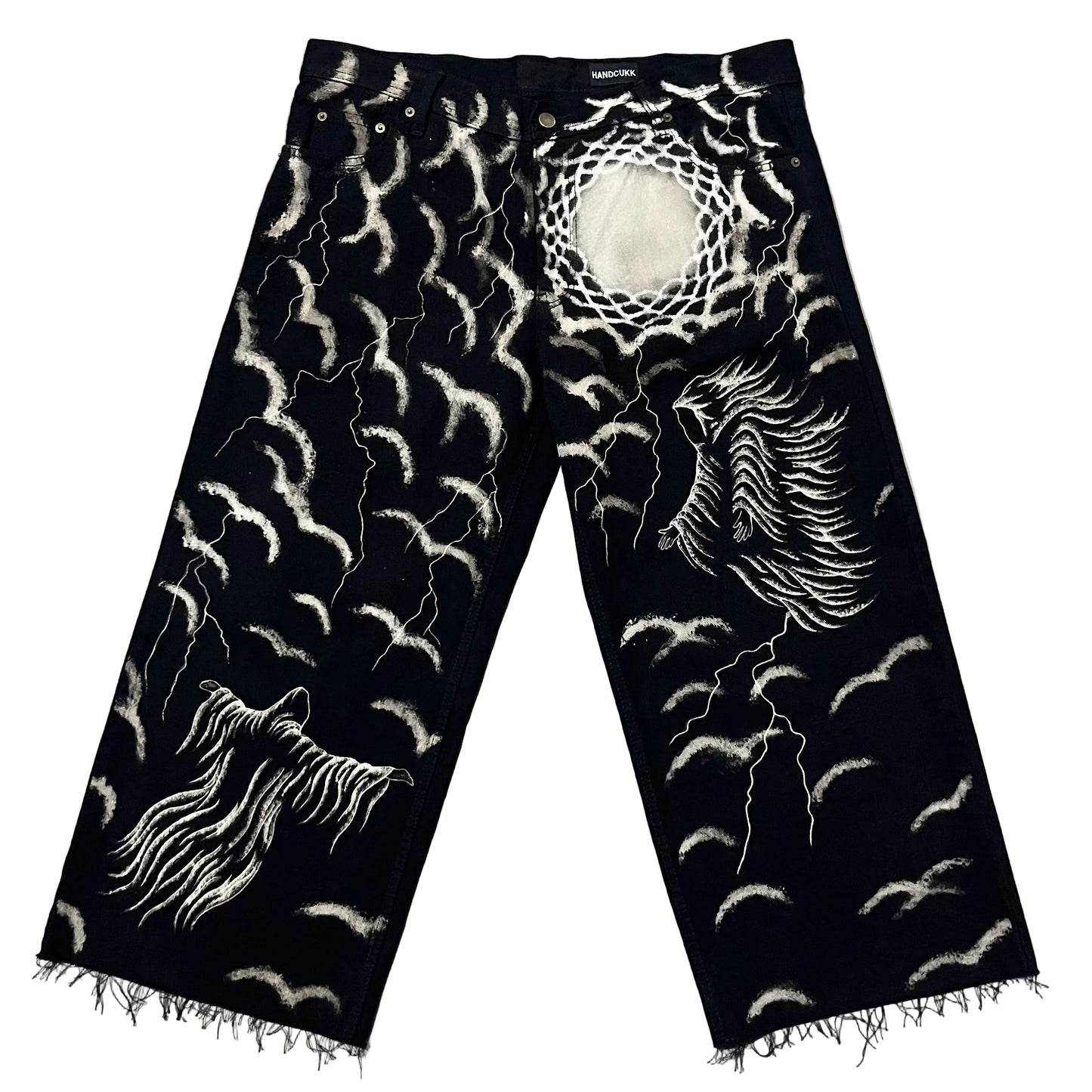 Black denim jeans with classic dark art designs, including a large winged figure on one leg, a ghostly figure on the other, and numerous lightning bolts and sky’s.