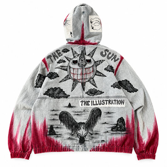 A heather blue vintage wash hooded denim jeans jacket with a detailed black ink illustration and red acid-wash accents, laid flat on white background. The graphic features a sun, clouds and the text 'THE SUN' and ‘THE ILLUSTRATION'.